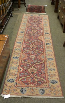 Lot 1316 - A narrow Arts & Crafts flat weave runner, probably India, the brick red lattice field of...