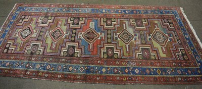 Lot 1342 - A Kurdish rug, the charcoal field with five stepped medallions enclosed by triple narrow...