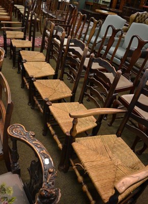 Lot 1356 - A set of seven oak rush seated Lancashire ladder back dining chairs including one carver,...