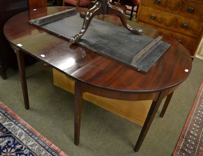 Lot 1381 - A mahogany dining table with two leaves and a baize lined crate for additional leaf storage