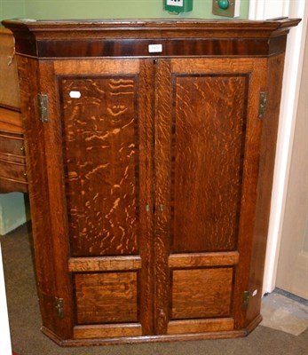 Lot 1400 - A George III oak hanging corner cupboard