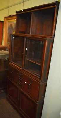 Lot 1402 - A sectional bookcase cabinet fitted with an arrangement of drawers, glazed cupboards and recesses