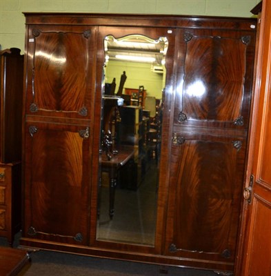 Lot 1407 - An Edwardian mahogany triple wardrobe with central mirrored door and fitted interior