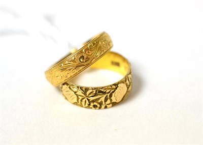 Lot 86 - 22ct gold ring and another in 18ct both with chased decoration (2)
