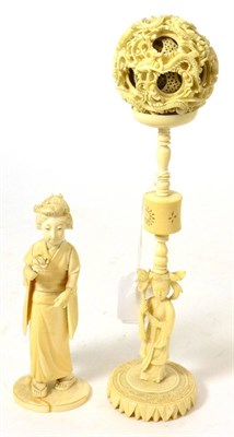 Lot 192 - A late 19th century carved ivory puzzle ball on stand and a figure of a geisha holding a flower (2)