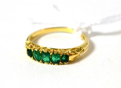 Lot 358 - An emerald five stone ring, the step cut emeralds in yellow claw settings, on a plain polished...