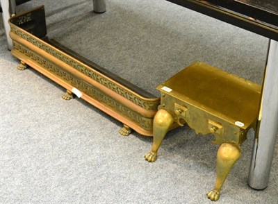 Lot 1027 - A 19th century brass footman and a Victorian pierced brass fender on paw feet