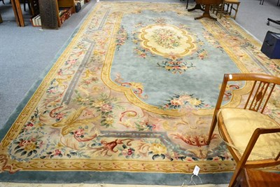 Lot 1075 - A large Savonnerie design carpet, the ice blue field centred by a cream floral medallion framed...