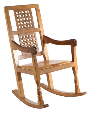 Lot 544 - Mouseman: A Robert Thompson English Oak Rocking Chair, with two lattice back panels, shaped...