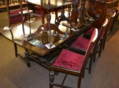 Lot 1275 - Oak draw leaf table and a set of six oak dining chairs with red cut velvet upholstery