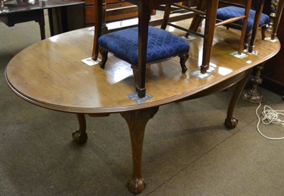 Lot 1286 - An extending walnut dining table on claw and ball feet