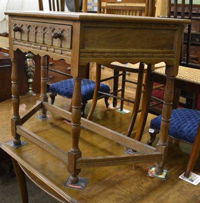 Lot 1287 - A Yorkshire School light oak credence table with carved frieze drawer with acorn handle