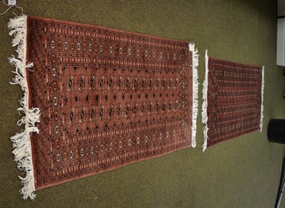 Lot 1329 - A Lahore Bukhara rug, Punjab, the pale rose pink field with two rows of quartered guls enclosed...