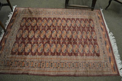 Lot 1342 - A Lahore Bukhara rug, Punjab, the field with three columns of quartered guls enclosed by...