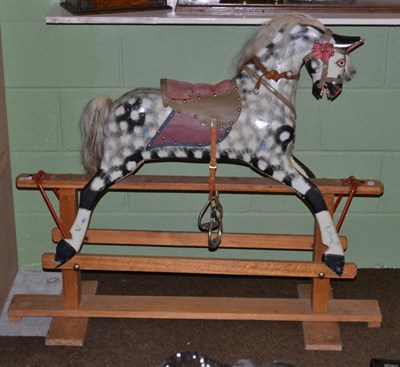 Lot 83 - A dapple grey wooden rocking horse on a trestle base