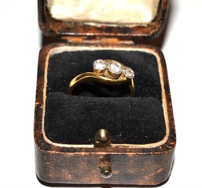 Lot 138 - An 18ct gold diamond three stone ring in a cross over setting