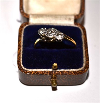 Lot 166 - An 18ct gold diamond three stone ring in a cross over setting