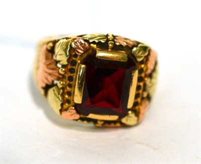 Lot 211 - A 'Black Hills' red stone ring, stamped 10K