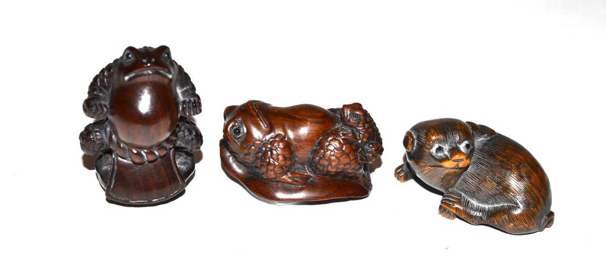 Lot 243 - Three carved hardwood netsukes; two toads and a dog