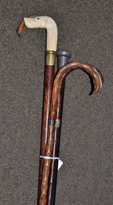 Lot 303 - A dog head walking stick, a silver topped stick and three others