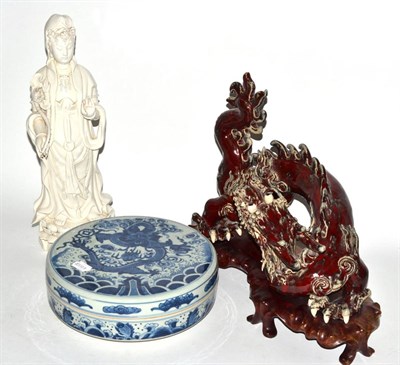 Lot 382 - A blanc de chine figure of Guanyin, a Chinese ceramic model of a dragon and a jar and cover