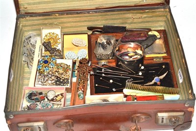 Lot 423 - A leather suitcase containing a small group of costume jewellery, hat pins, silver bangle, knitting