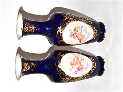 Lot 442 - A pair of Berlin baluster vases, with hand painted oval cherub vignettes on cobalt blue ground...