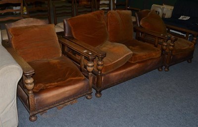 Lot 1150 - A three piece 1920s oak suite with two adjustable armchairs and two seater sofa