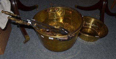 Lot 1157 - A large brass pan with iron swing handle, brass basin and fire tools