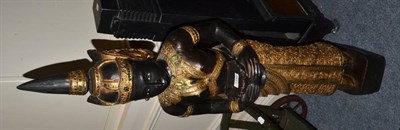 Lot 1192 - An ebonised parcel gilt wooden statue of a deity