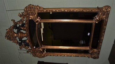 Lot 1252 - A reproduction gilt mirror surmounted by urns, flowers and putti