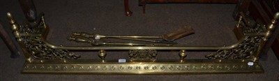 Lot 1285 - An ornate brass fender and a set of three fire tools