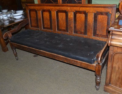 Lot 1309 - An 18th century panelled oak settle with stuffed over seat