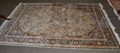 Lot 1324 - An artificial silk rug, the apple green field of vines centred by a roundel medallion framed by...