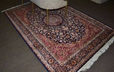 Lot 1325 - An artificial silk rug, the indigo field of vines centred by a roundel medallion framed by...