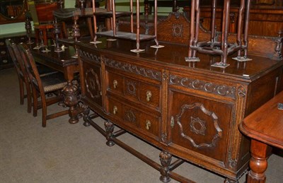 Lot 1361 - A 1920s carved oak dining room suite, comprising sideboard, draw leaf dining table and six chairs