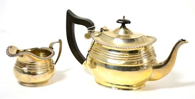 Lot 153 - Silver teapot, 14cm high and matching milk jug with gadrooned edge, 8cm high