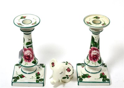 Lot 180 - A pair of Wemys cabbage rose candlesticks together with a Plichta model of an elephant