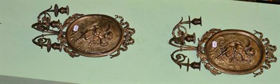 Lot 298 - A pair of oval brass wall sconces with embossed cherub decoration