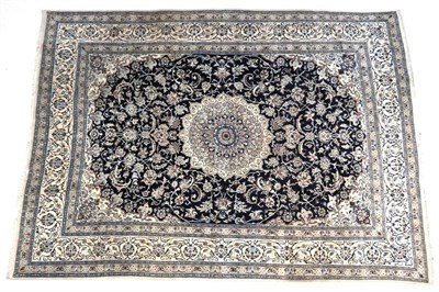 Lot 691 - Nain Carpet Central Iran, circa 1970 The indigo field of vines around a flower head medallion...