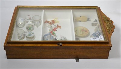 Lot 356 - A small glazed display cabinet containing a small quantity of miniature porcelain and glass