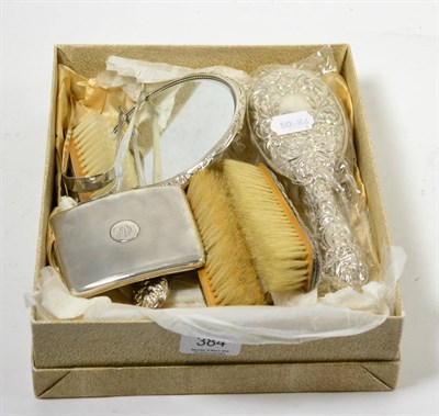 Lot 384 - Two pairs of sugar tongs, a silver cigarette case and a silver backed dressing table set