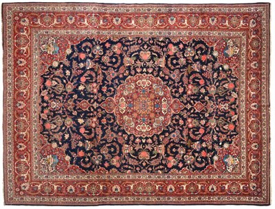 Lot 705 - Kashan Carpet Central Iran, circa 1930  The indigo field of scrolling vines around a cusped...