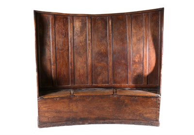 Lot 710 - A George III Ash and Elm Panel Back Settle, early 19th century, of curved form with winged...