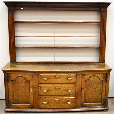 Lot 715 - A Late George III Oak Enclosed Dresser, circa 1800, the rack with two shelves between fluted...