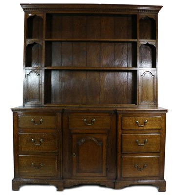 Lot 717 - A George III Oak Enclosed Dresser, early 19th century, the rack with a dentil cornice above two...