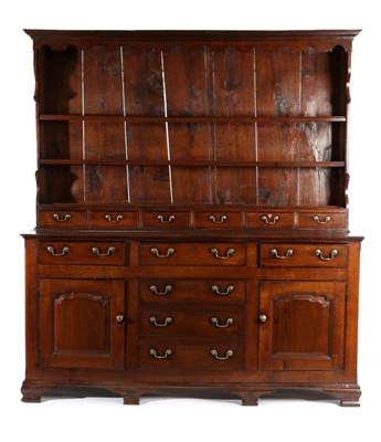 Lot 720 - A George III Oak Enclosed Dresser, early 19th century, the rack with arched apron above two...