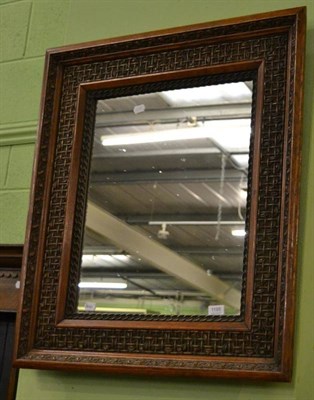 Lot 1195 - An oak wall mirror carved with trellis and leaf design