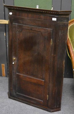 Lot 1202 - A Georgian oak hanging corner cabinet