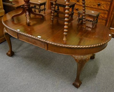 Lot 1217 - An oval oak dining table with claw and ball feet and one extra leaf (no winder)